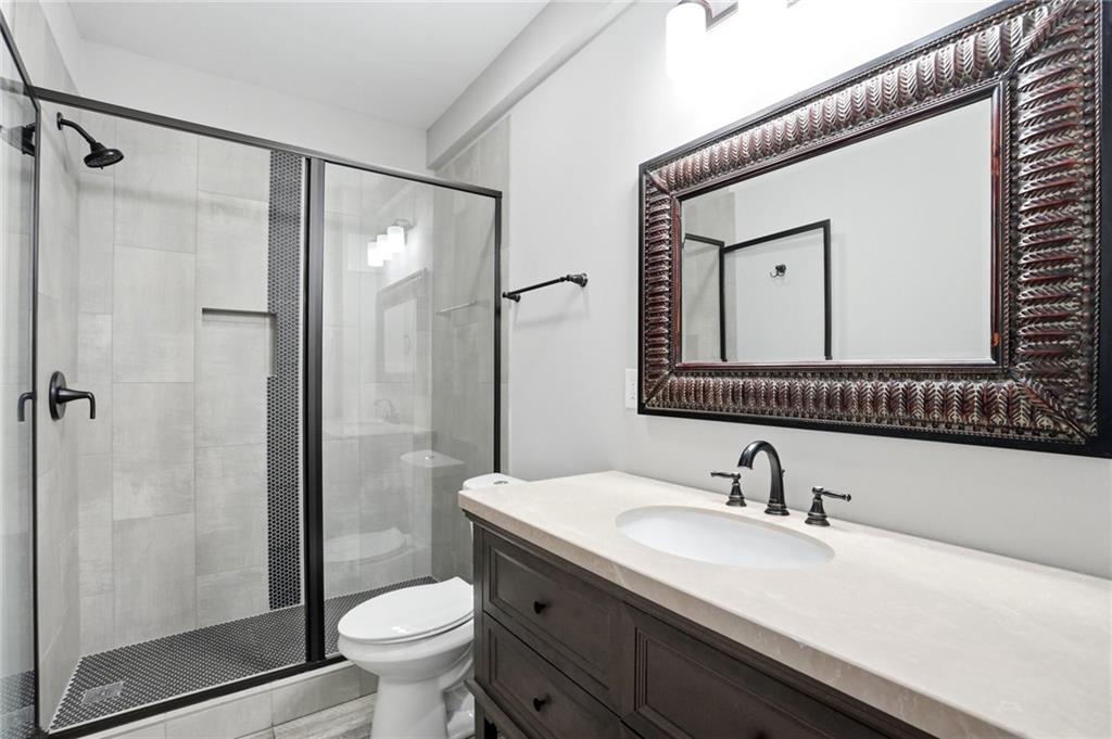 7812 Keepsake Lane Flowery Branch, GA 30542 - Photo 24 of 78 a bathroom with a granite countertop sink toilet and shower