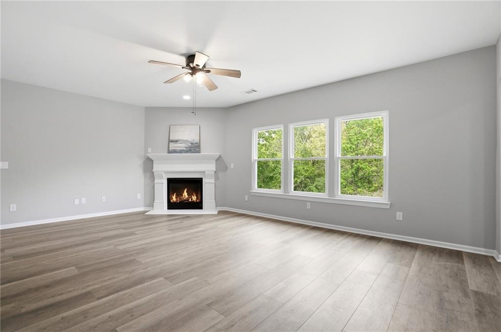 7812 Keepsake Lane Flowery Branch, GA 30542 - Photo 6 of 78 a view of an empty room with wooden floor fireplace and a window