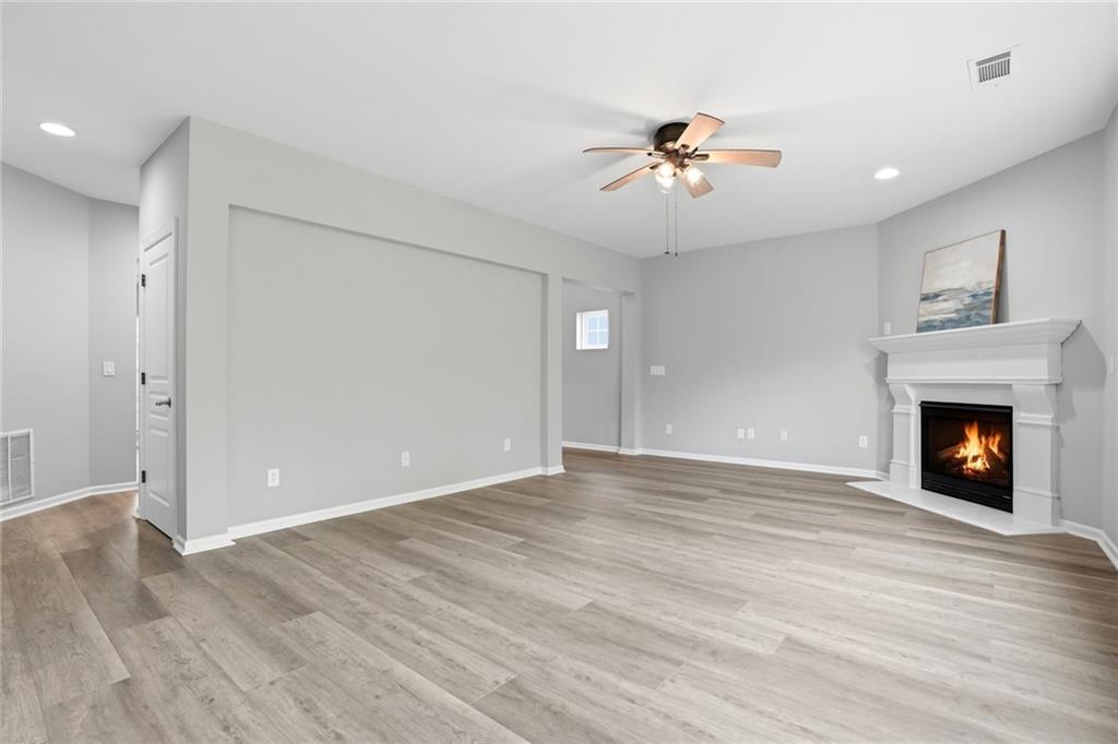 7812 Keepsake Lane Flowery Branch, GA 30542 - Photo 7 of 78 a view of an empty room with wooden floor fireplace and a window