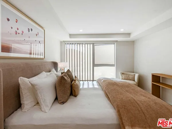 a bedroom with a bed and a large window