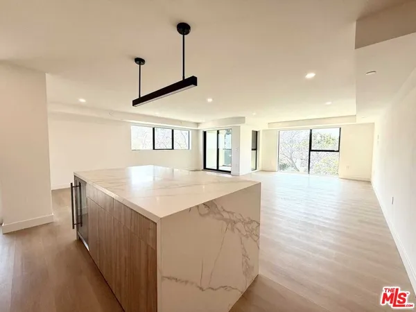 a kitchen with stainless steel appliances granite countertop a sink a microwave oven a refrigerator and white cabinets