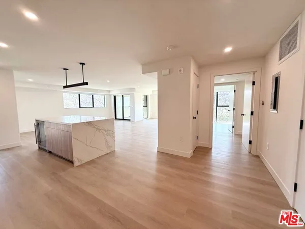a view of a kitchen with wooden floor and a refrigerator