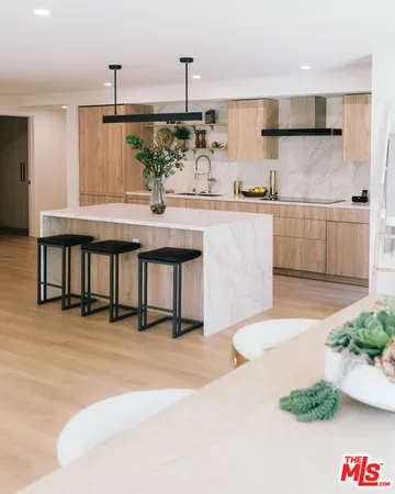 a bathroom with a sink a mirror and potted plant