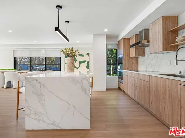 a view of a kitchen with kitchen island a counter top space appliances and cabinets