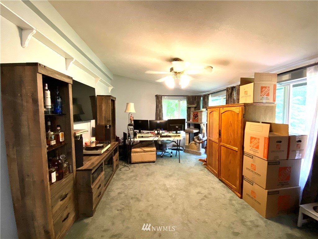 18436 Loganberry Street Southwest Rochester, WA 98579 - Photo 14 of 29 a living room with furniture a flat screen tv and a refrigerator