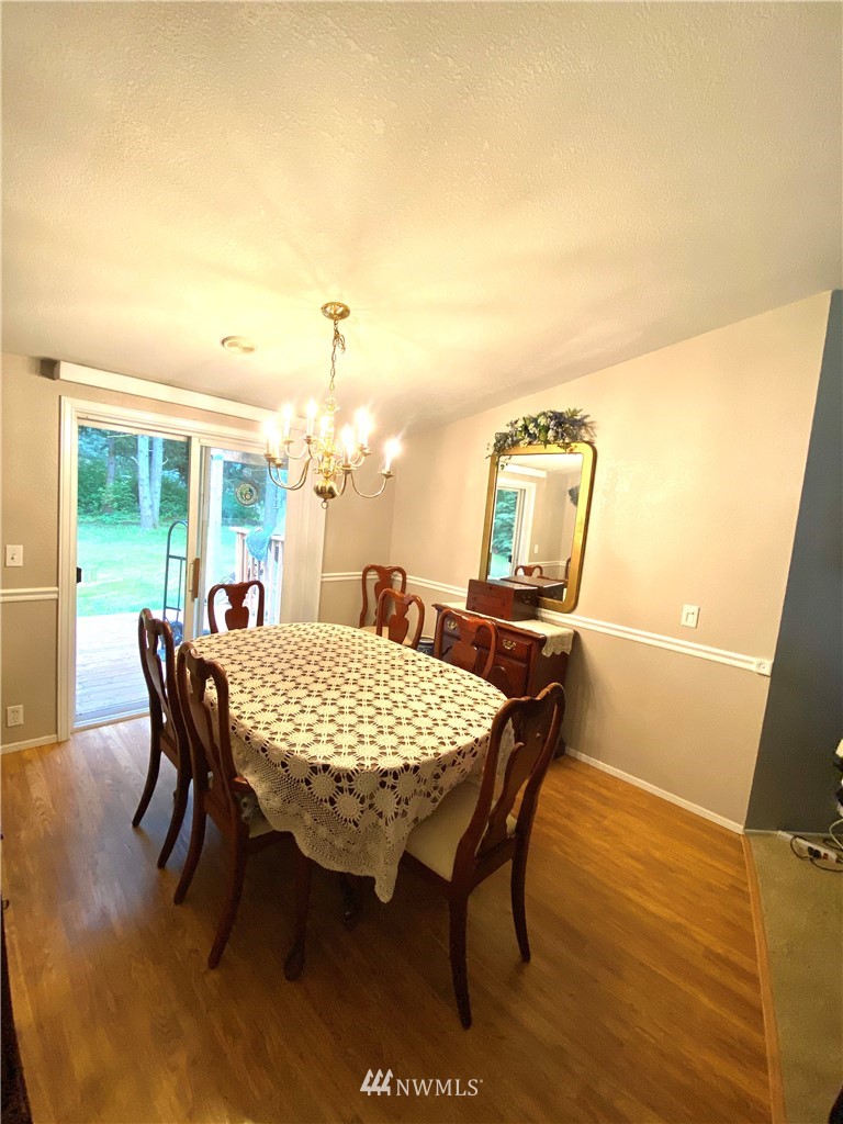 18436 Loganberry Street Southwest Rochester, WA 98579 - Photo 6 of 29 a view of a dining room with furniture and wooden floor