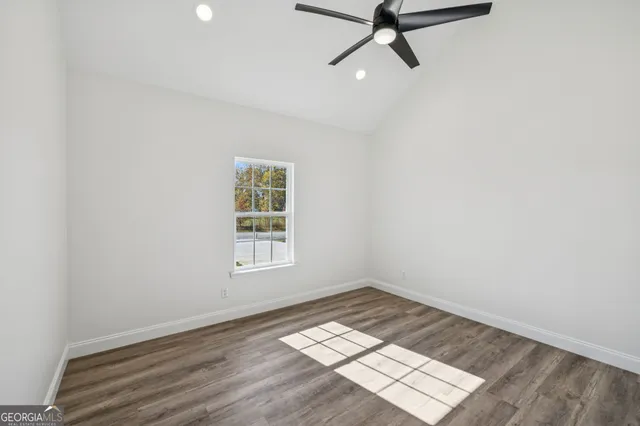 an empty room with a window and a ceiling fan