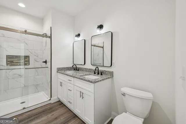 a bathroom with a granite countertop sink toilet and shower