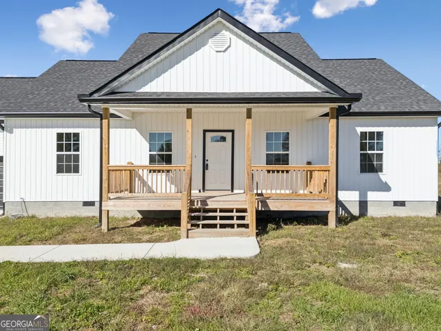 a front view of a house with a yard outdoor seating and garage