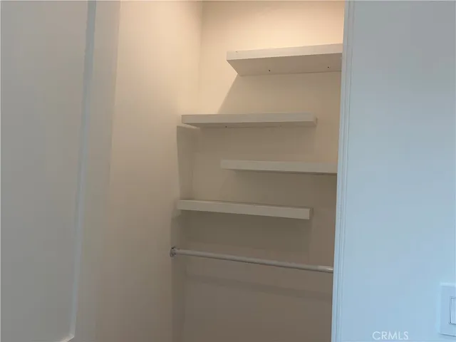 a view of an empty room with closet and entryway