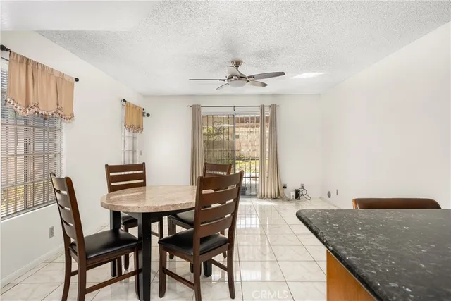 a kitchen with stainless steel appliances kitchen island granite countertop a refrigerator a stove a sink dishwasher with a dining table and chairs with wooden floor