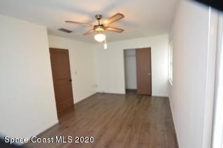 1554 Meadowbrook Road Northeast Palm Bay, FL 32905 - Photo 14 of 37 an empty room with wooden floor fan and windows