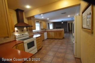 1554 Meadowbrook Road Northeast Palm Bay, FL 32905 - Photo 15 of 37 a kitchen with stainless steel appliances granite countertop a stove a sink and a microwave