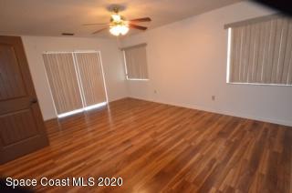 1554 Meadowbrook Road Northeast Palm Bay, FL 32905 - Photo 21 of 37 an empty room with wooden floor ceiling fan and window