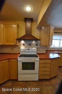 1554 Meadowbrook Road Northeast Palm Bay, FL 32905 - Photo 23 of 37 a stove top oven sitting inside of a kitchen