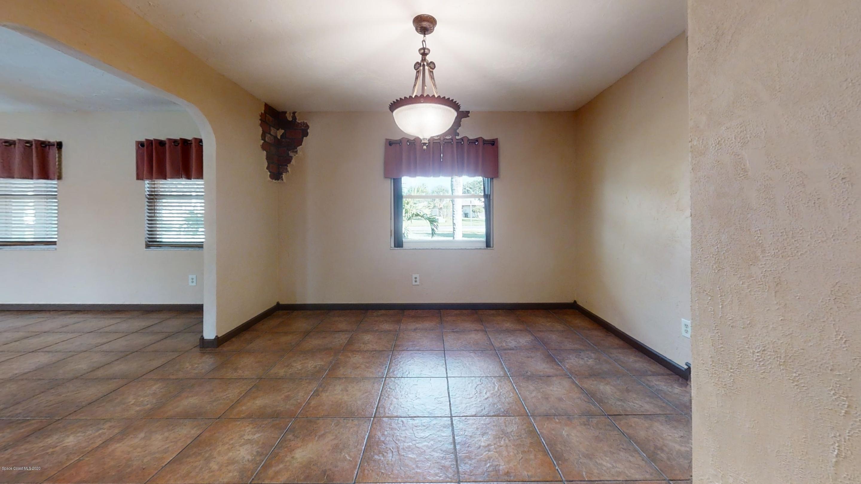 1554 Meadowbrook Road Northeast Palm Bay, FL 32905 - Photo 26 of 37 a view of an empty room with window and chandelier fan