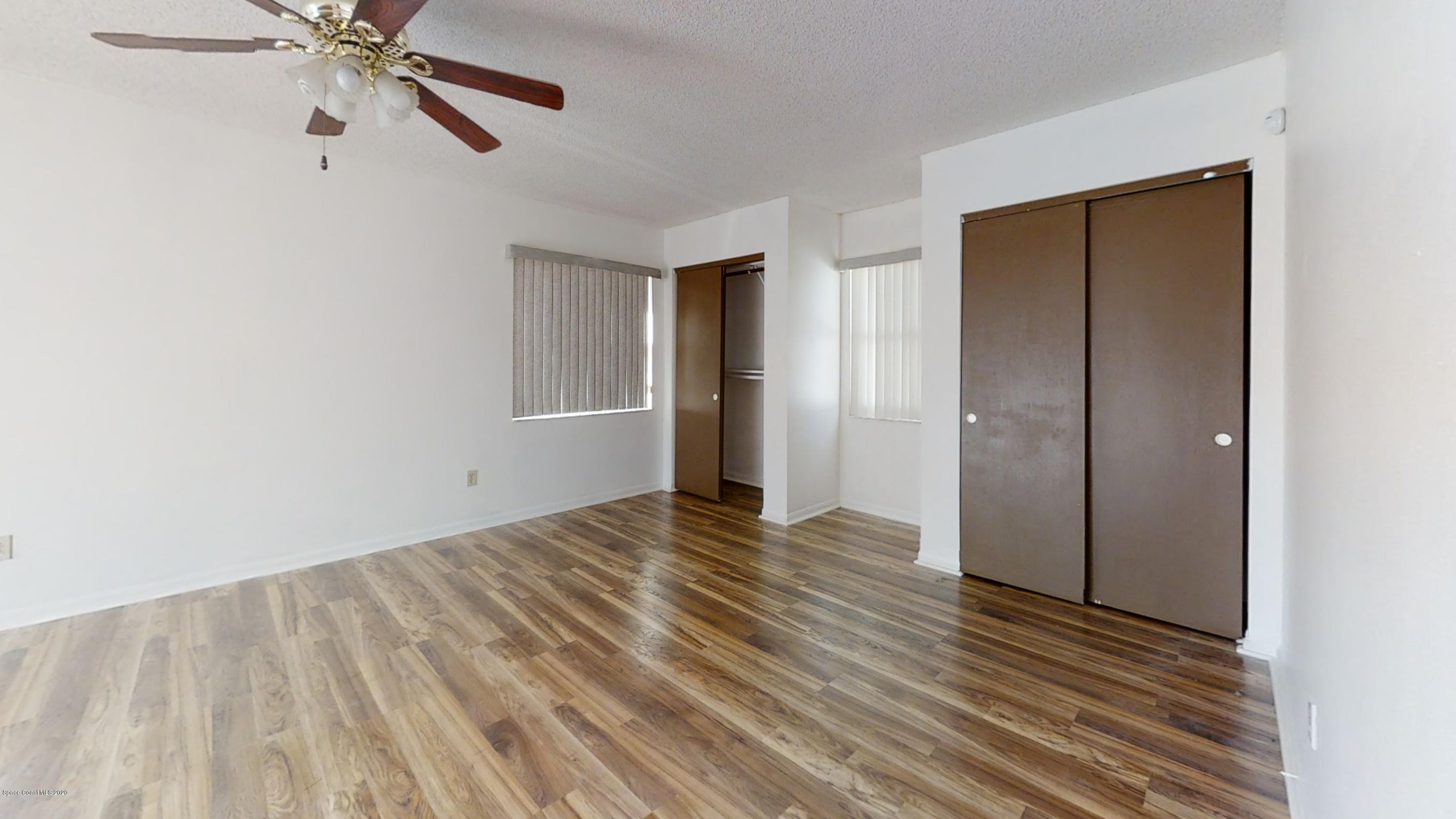 1554 Meadowbrook Road Northeast Palm Bay, FL 32905 - Photo 28 of 37 a view of an empty room with wooden floor and a ceiling fan