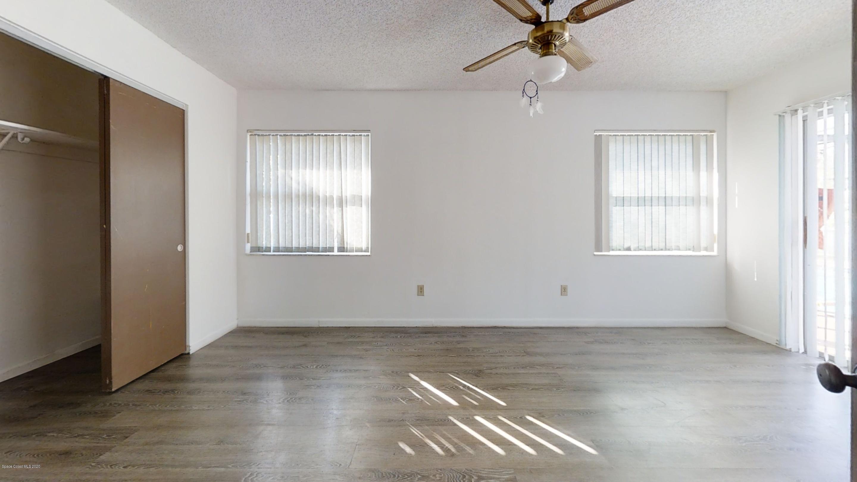 1554 Meadowbrook Road Northeast Palm Bay, FL 32905 - Photo 30 of 37 an empty room with windows and fan