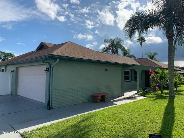 1554 Meadowbrook Road Northeast Palm Bay, FL 32905 - Photo 4 of 37 a backyard of a house with table and chairs