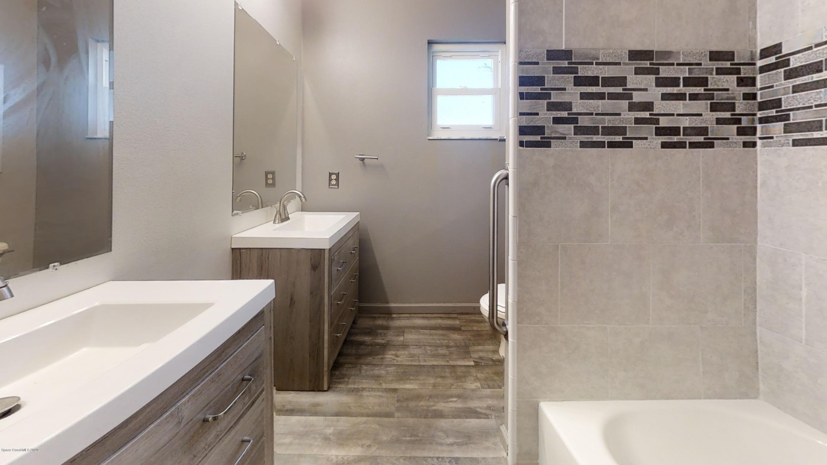 1554 Meadowbrook Road Northeast Palm Bay, FL 32905 - Photo 35 of 37 a bathroom with a sink a vanity and a mirror