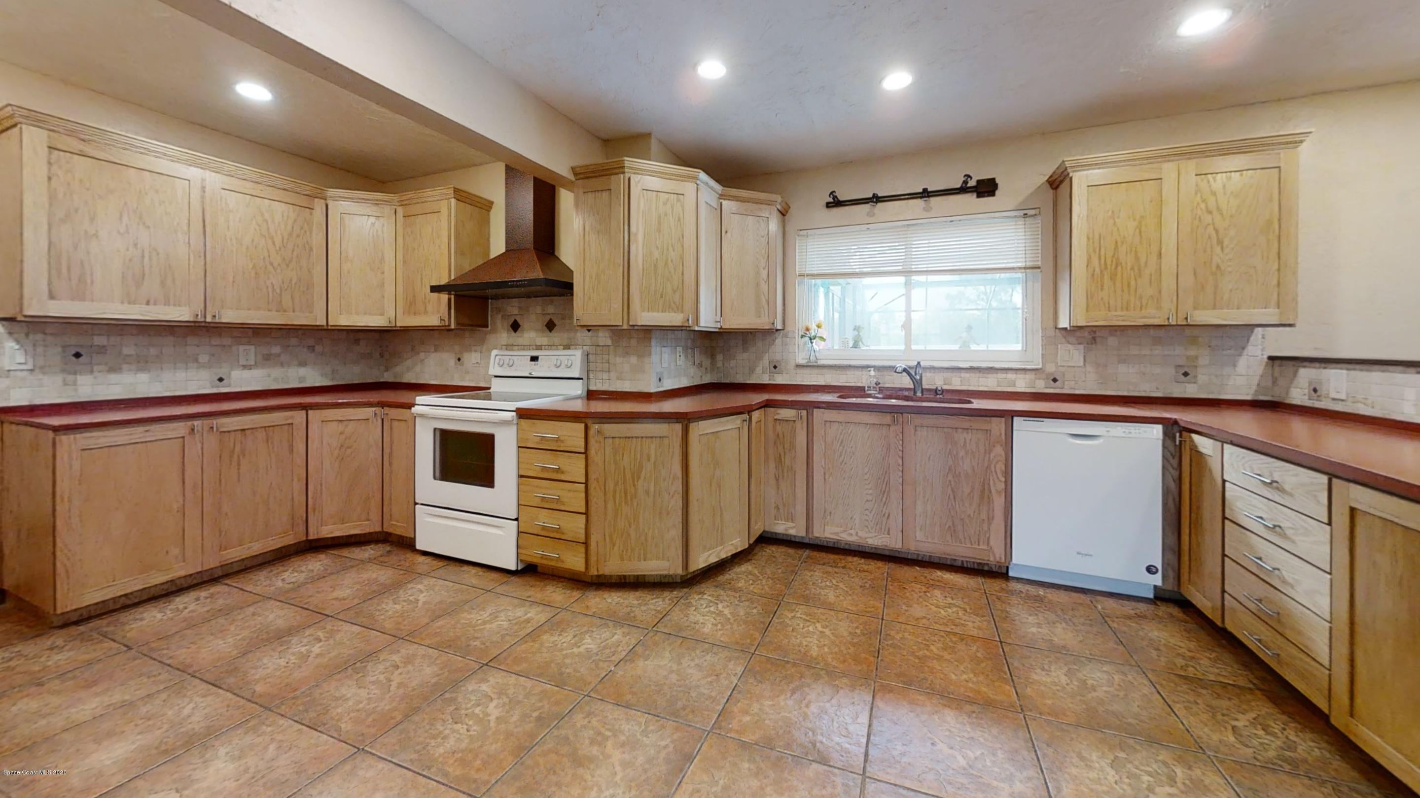1554 Meadowbrook Road Northeast Palm Bay, FL 32905 - Photo 36 of 37 a kitchen with a sink stove and cabinets