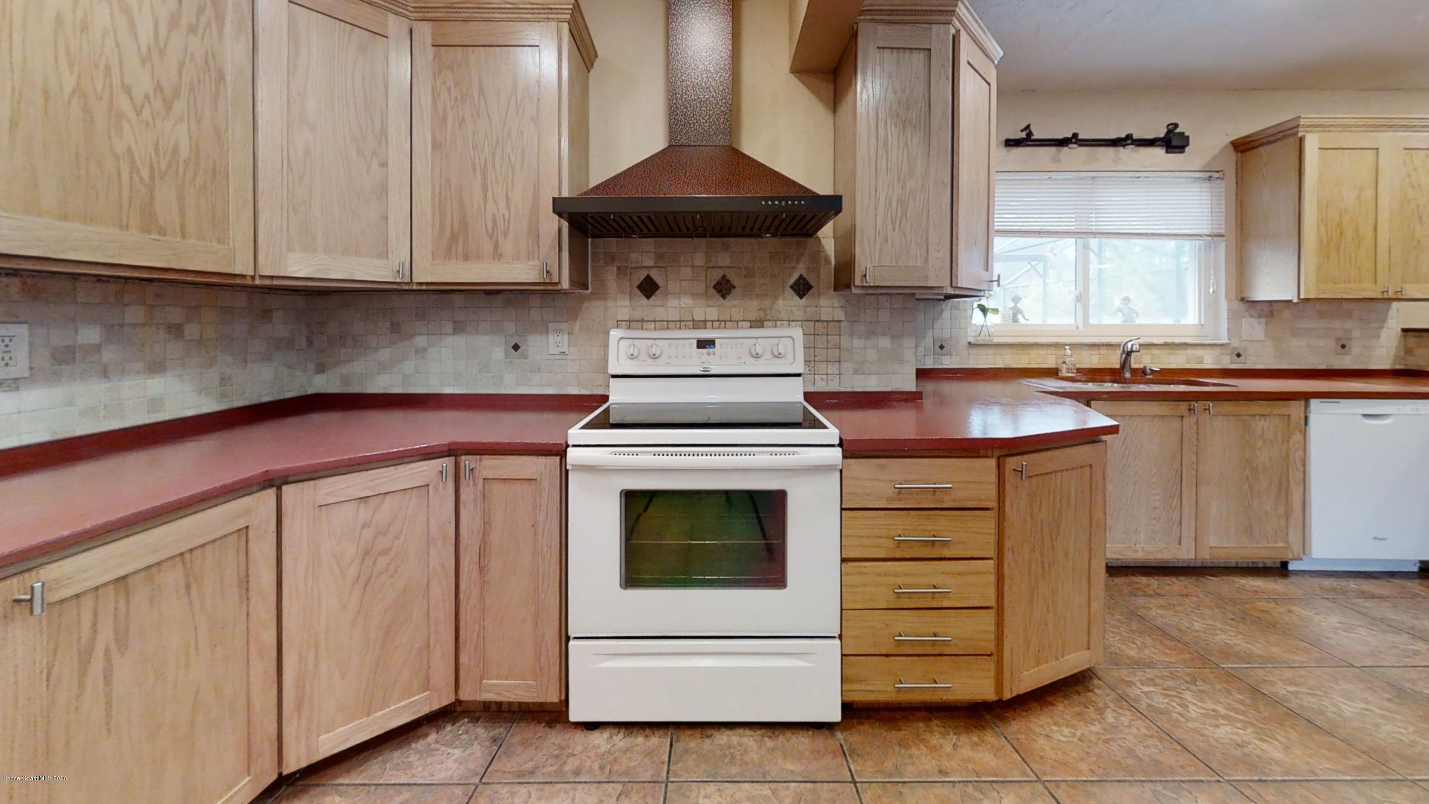 1554 Meadowbrook Road Northeast Palm Bay, FL 32905 - Photo 37 of 37 a kitchen with stainless steel appliances granite countertop white cabinets and sink