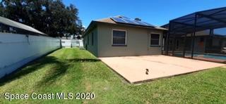 1554 Meadowbrook Road Northeast Palm Bay, FL 32905 - Photo 9 of 37 a backyard of a house with plants and a yard