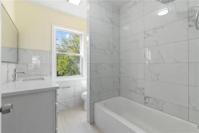 a view of an empty room with window and bathroom