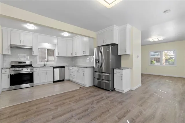 a kitchen with a refrigerator a stove a microwave and cabinets