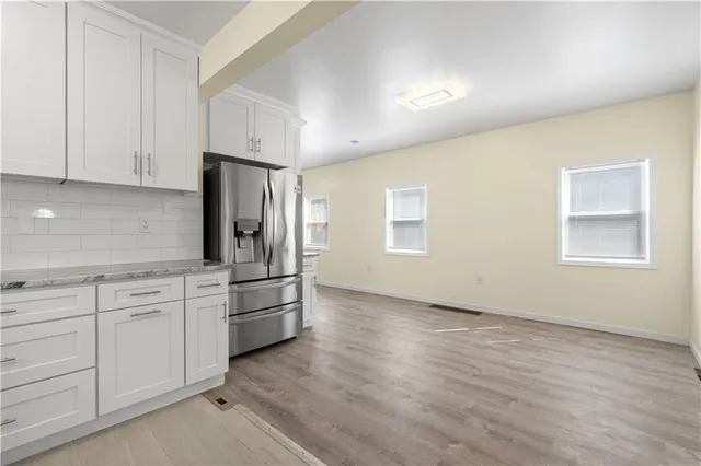 a kitchen with granite countertop white cabinets and stainless steel appliances