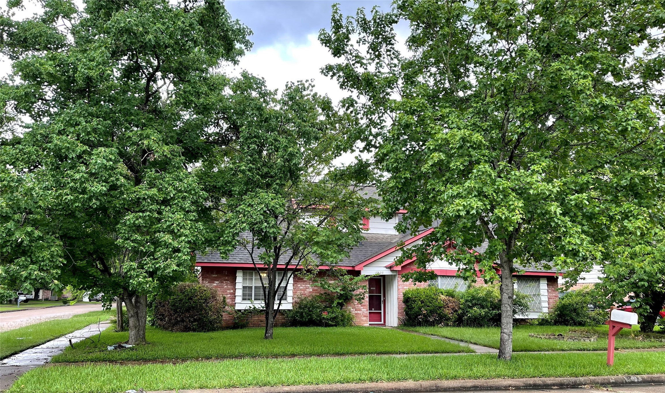a front view of a house with a yard and trees