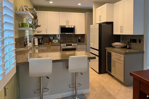 a kitchen with stainless steel appliances granite countertop a refrigerator stove microwave and sink