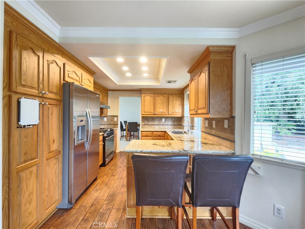 21029 Northview Drive Walnut, CA 91789 - Photo 6 of 22 a kitchen with stainless steel appliances granite countertop a refrigerator a sink dishwasher and wooden cabinets with wooden floor