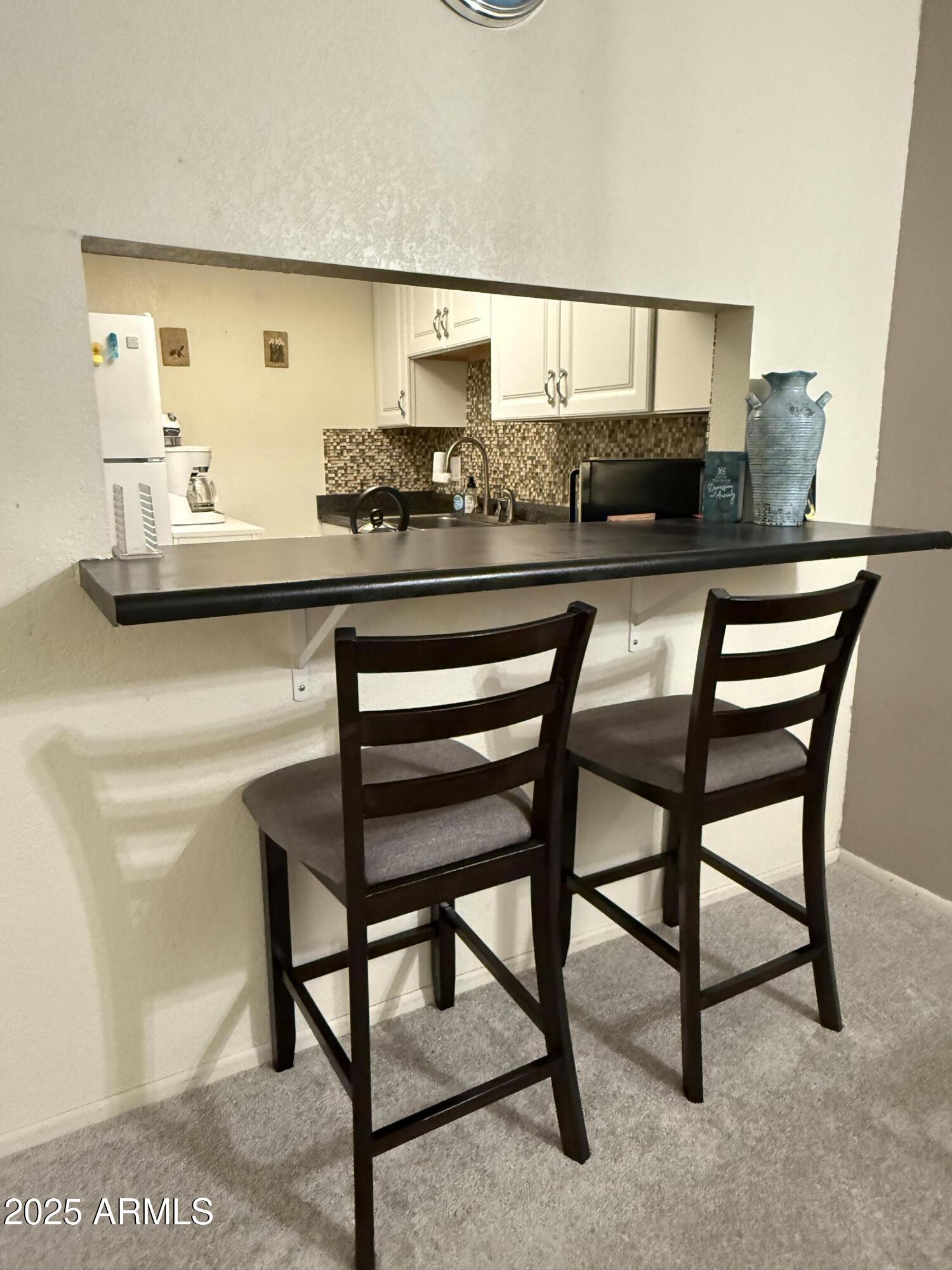 8649 East Royal Palm Road, Unit 104 Scottsdale, AZ 85258 - Photo 12 of 20 a kitchen with a table and chairs in it
