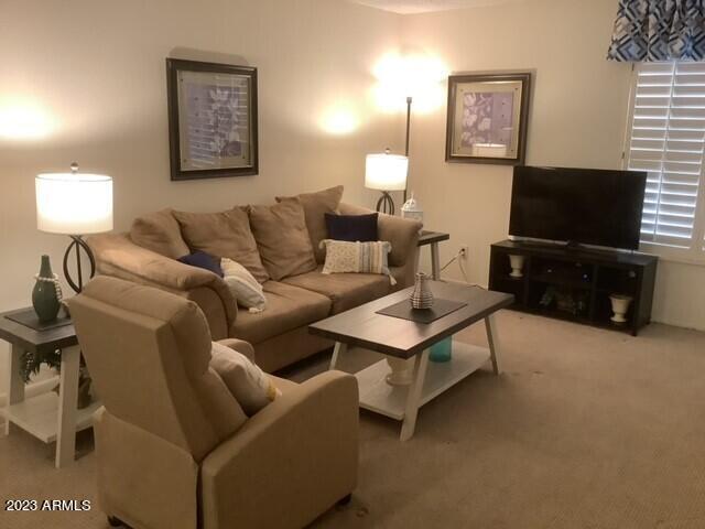 8649 East Royal Palm Road, Unit 104 Scottsdale, AZ 85258 - Photo 3 of 20 a living room with furniture a flat screen tv and a window