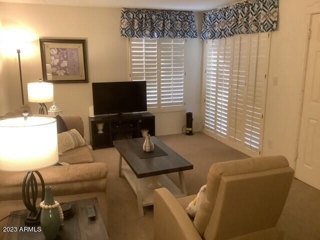 8649 East Royal Palm Road, Unit 104 Scottsdale, AZ 85258 - Photo 4 of 20 a living room with furniture and a flat screen tv