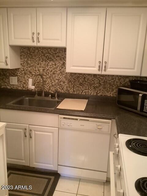 8649 East Royal Palm Road, Unit 104 Scottsdale, AZ 85258 - Photo 7 of 20 a kitchen with white cabinets and white appliances