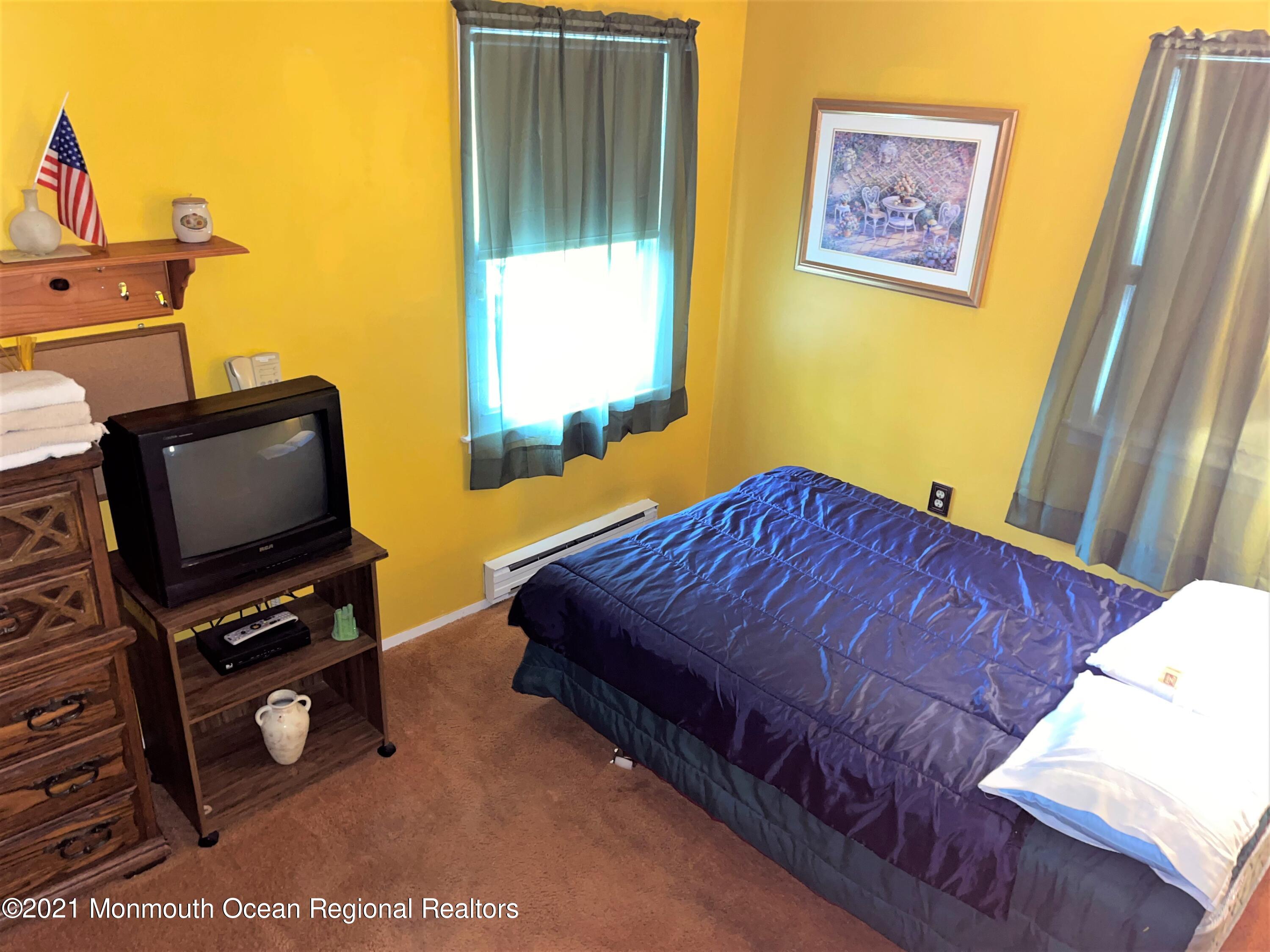 19 Augusta Road, Unit 73 Whiting, NJ 08759 - Photo 11 of 11 a bedroom with a bed and flat screen tv