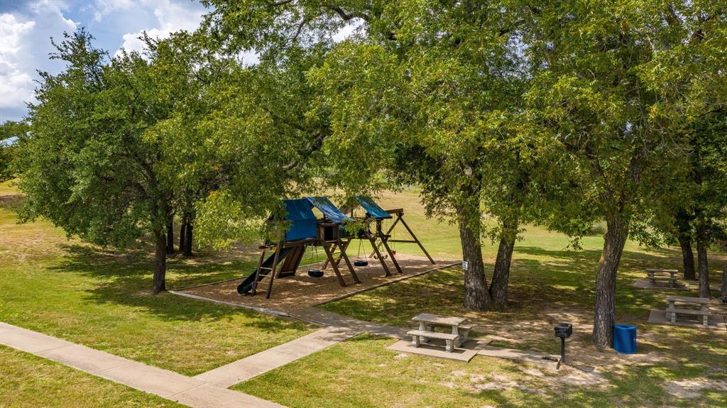 2280 Compass Way Bluff Dale, TX 76433 - Photo 24 of 40 a view of swimming pool with lawn chairs and large trees