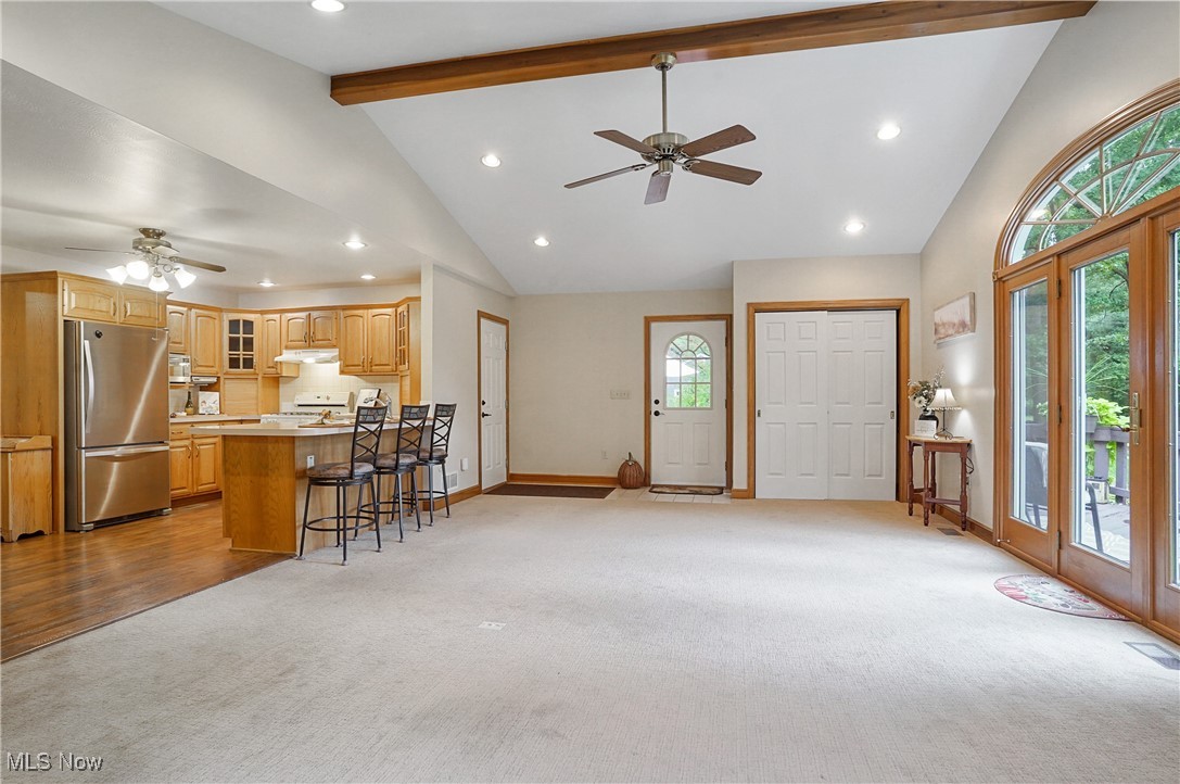 449 East Comet Road Clinton, OH 44216 - Photo 23 of 39 Living room with high vaulted ceiling, light colored carpet, ceiling fan, and beamed ceiling