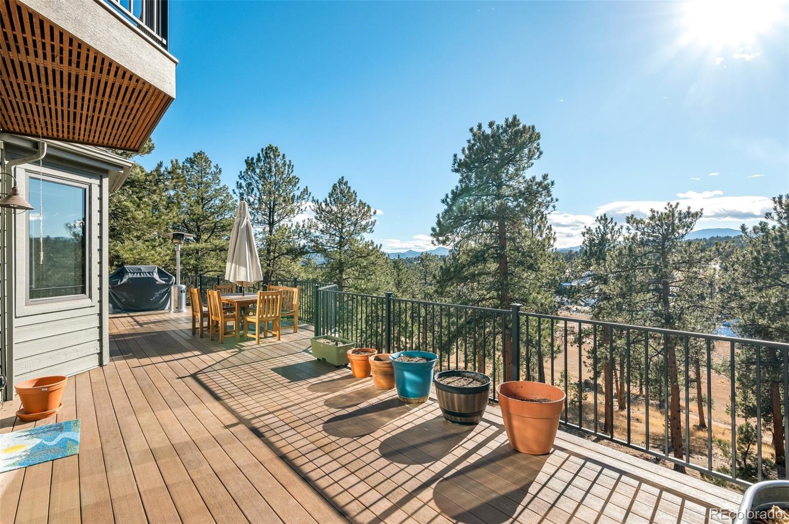 30754 Stratton Court Evergreen, CO 80439 - Photo 31 of 40 a balcony with wooden floor table and chairs
