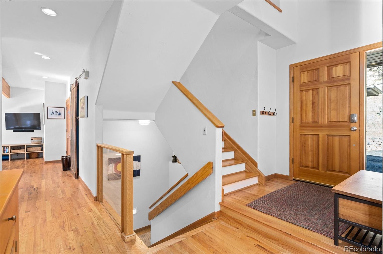 30754 Stratton Court Evergreen, CO 80439 - Photo 5 of 40 a view of a livingroom with wooden floor and stairs