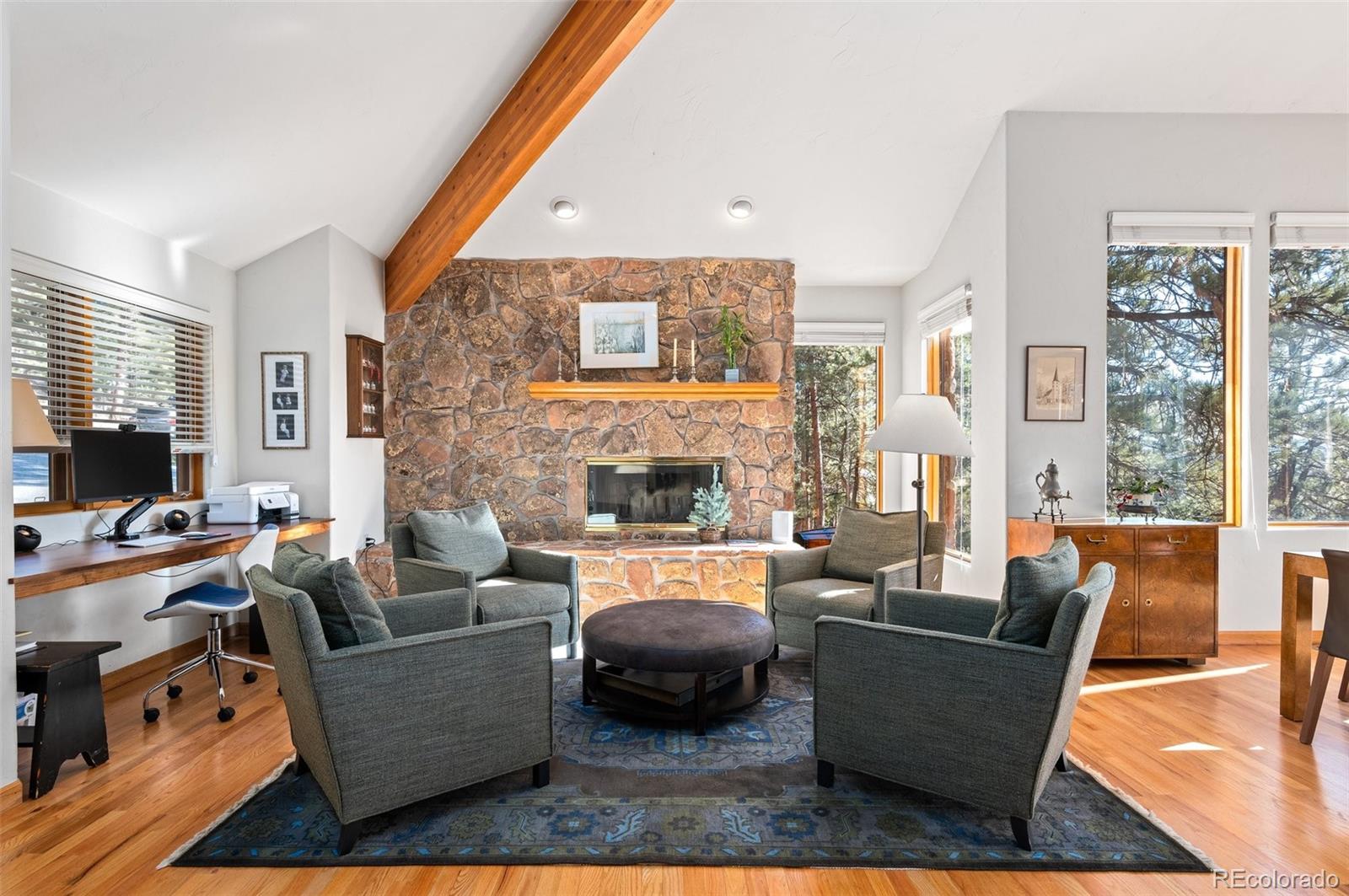30754 Stratton Court Evergreen, CO 80439 - Photo 8 of 40 a living room with fireplace furniture and a large window