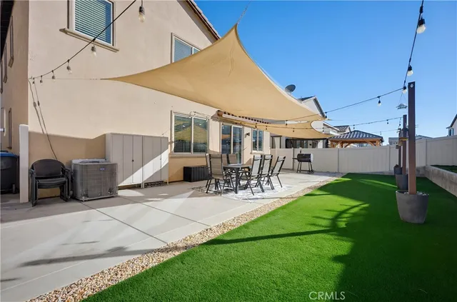 a view of a patio with table and chairs with plants and wooden fence