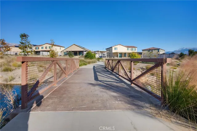 a view of a house with a small yard and a wooden deck