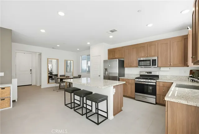 a kitchen with a sink a counter top space stainless steel appliances and cabinets