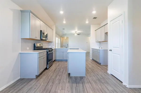 a kitchen with a sink cabinets stainless steel appliances and a window