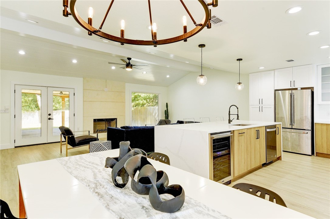 5006 Buffalo Pass Austin, TX 78745 - Photo 1 of 1 a kitchen with a refrigerator a stove and a dining table with wooden floor