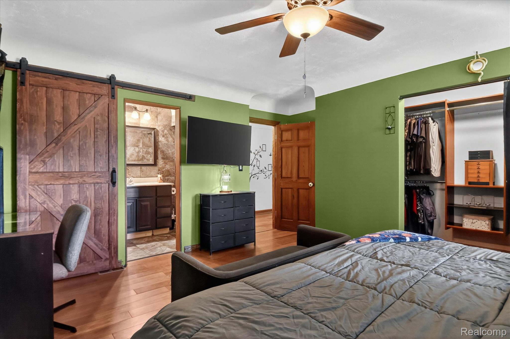3949 West Burns Line Road Brown City, MI 48416 - Photo 26 of 70 Spacious room featuring wood-finish flooring, a ceiling fan with light fixture, and a built-in closet with shelving and hanging rods