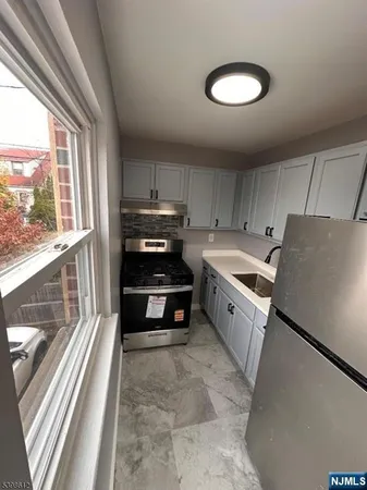 a kitchen with stainless steel appliances a stove a sink and a refrigerator